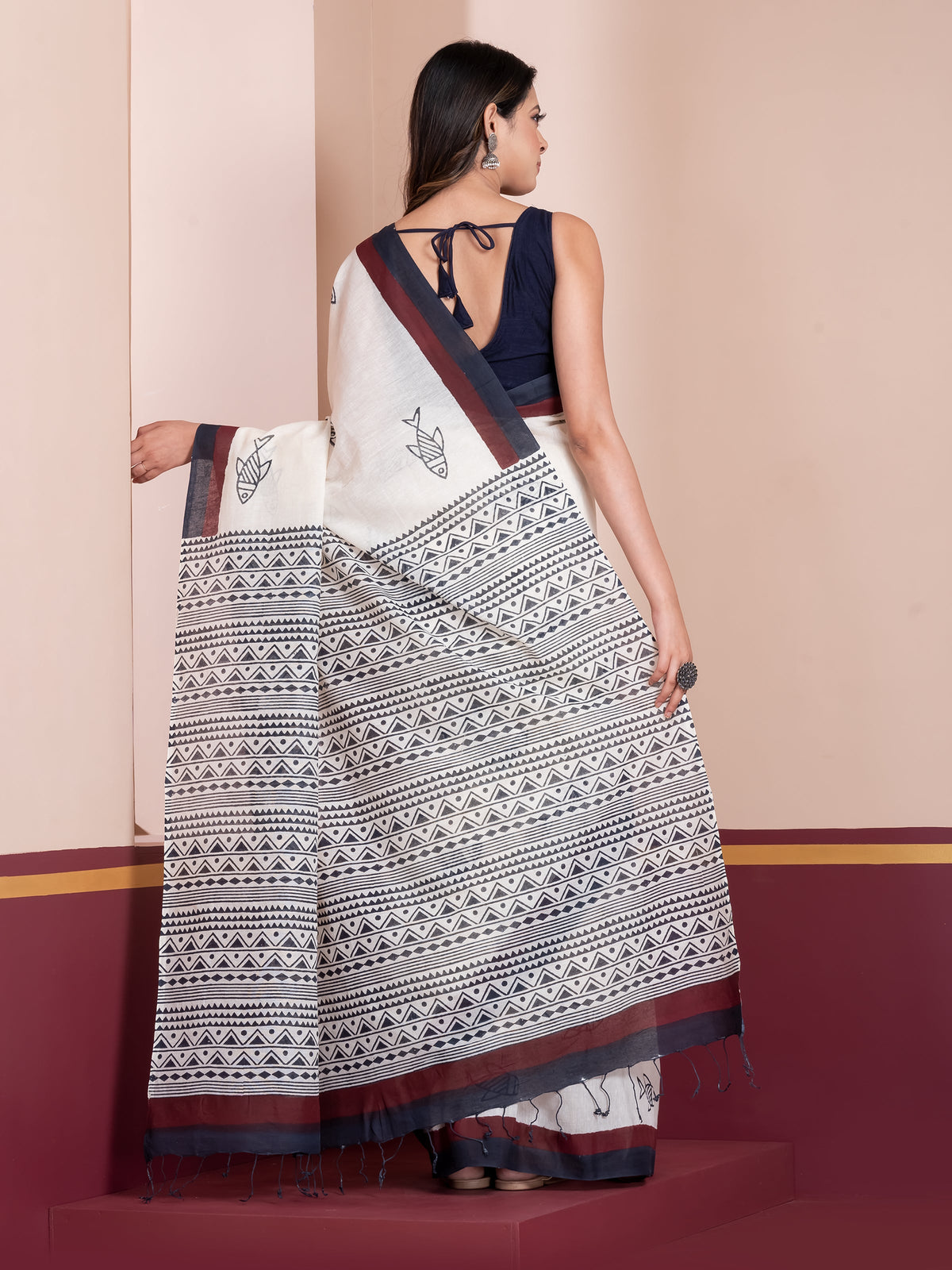 A woman draped in a white khadi cotton saree with black and maroon handblock print from ShopAaMe.