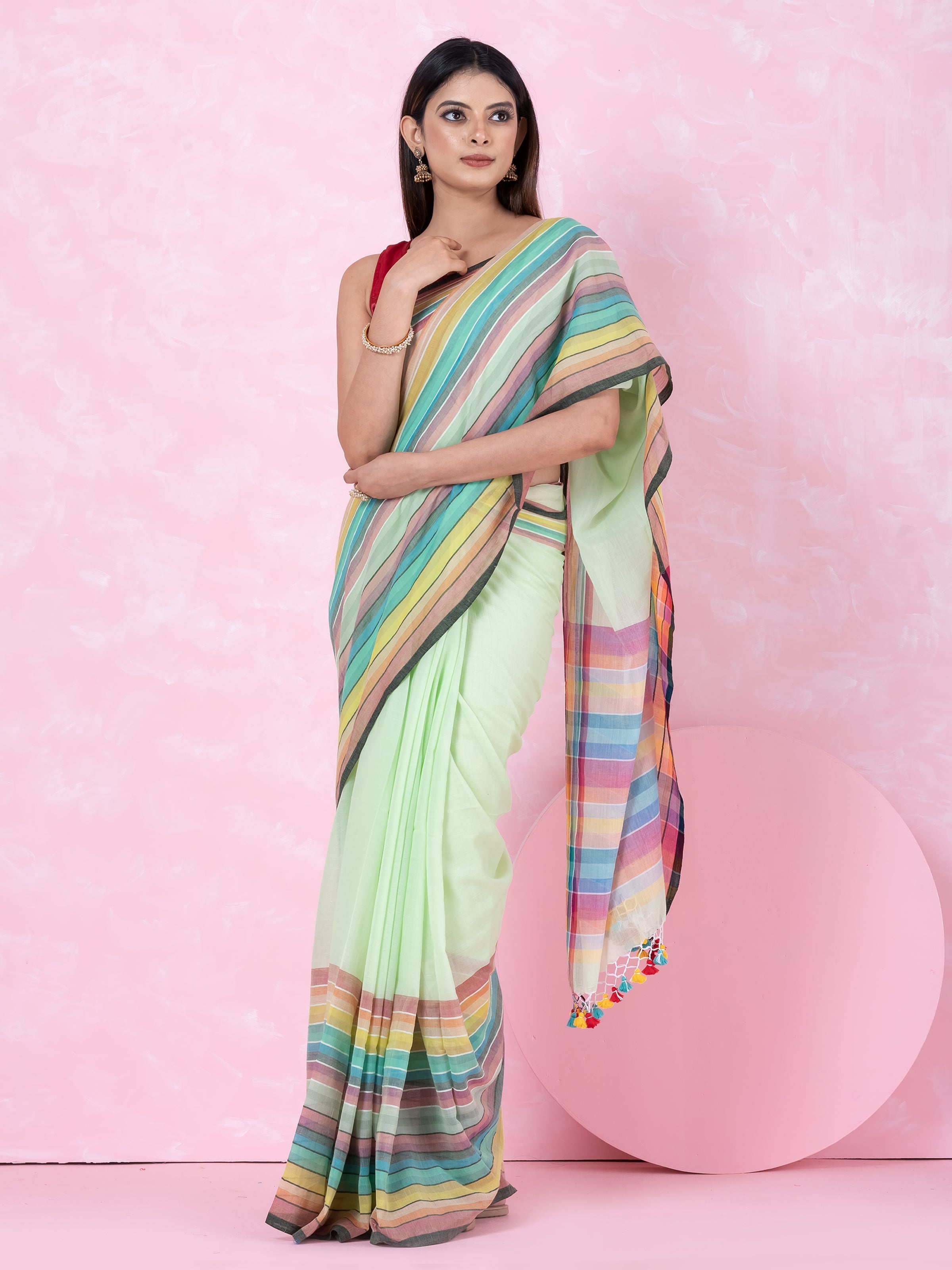 A woman modeling a saree with aqua green color and multicolored block stripes by Shopaame.
