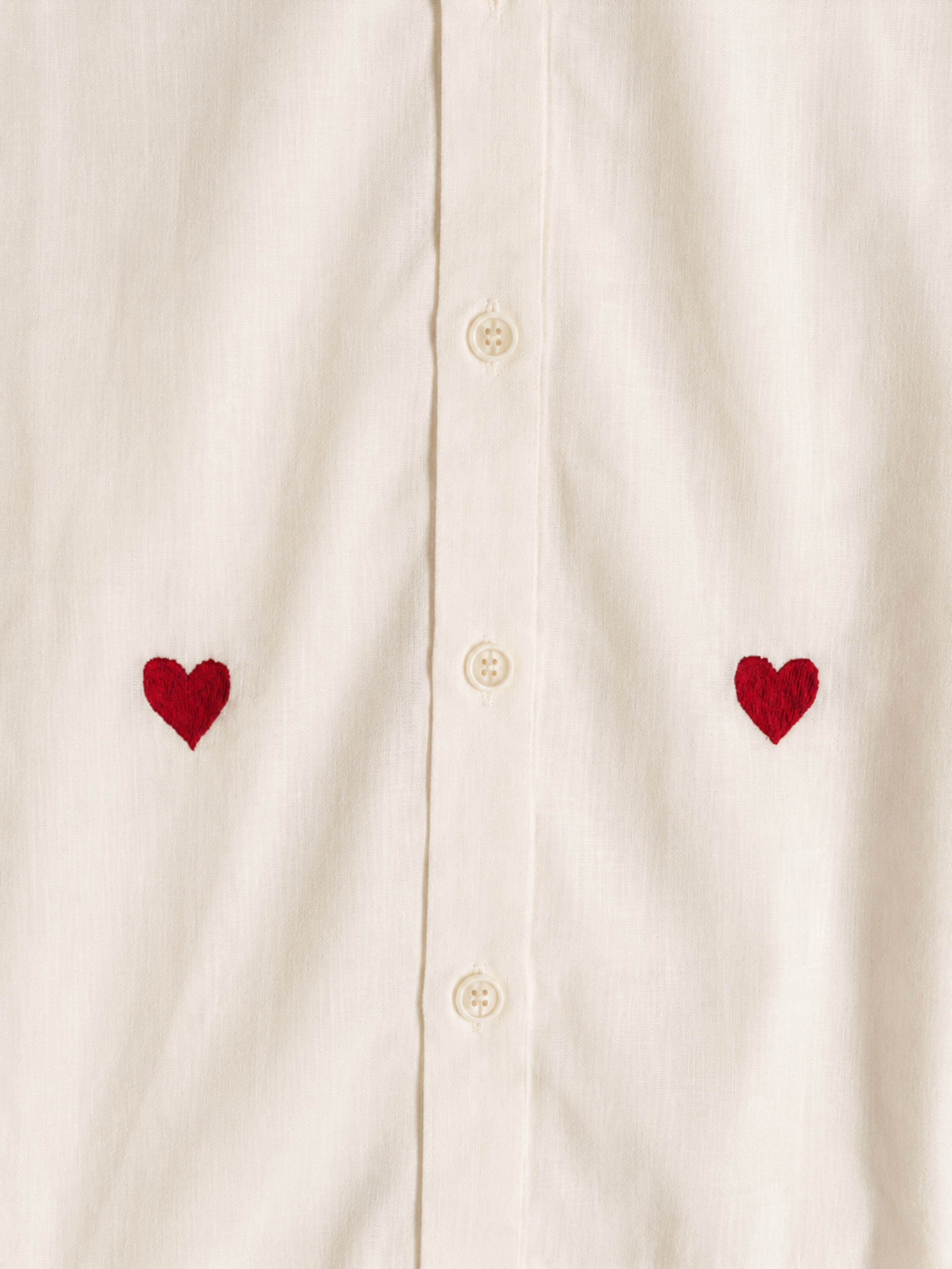 Off-white shirt with red heart embroidery on a white background