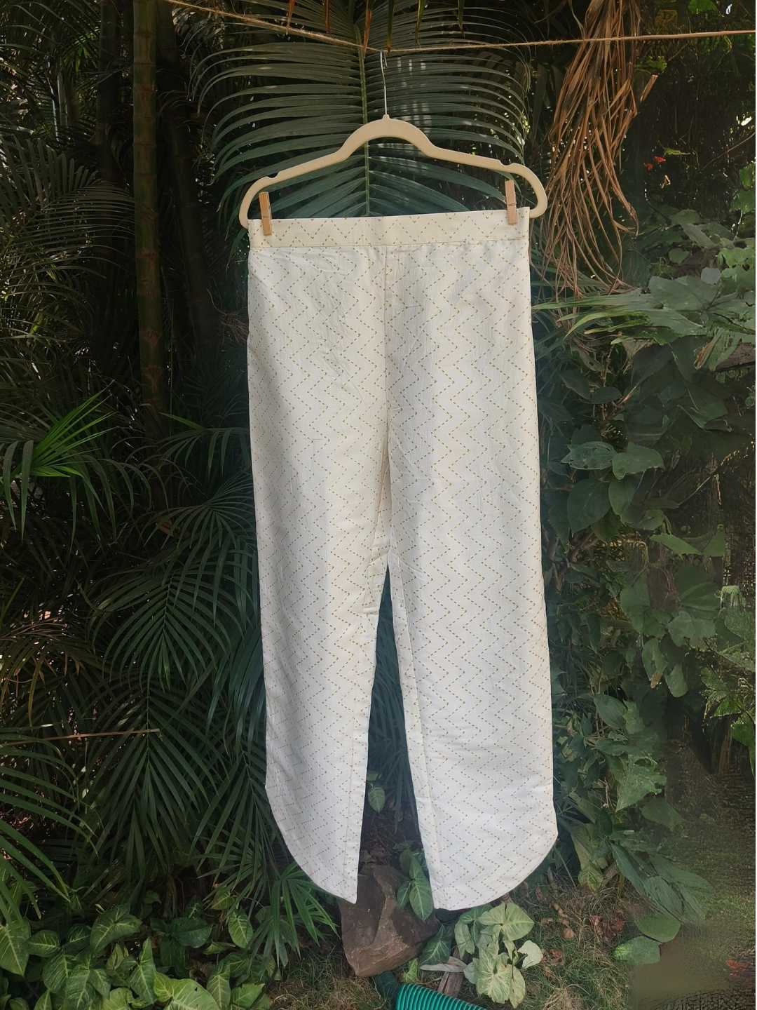 Selene Pants- Kosa Silk with Gold Weave | Jhultaru. Fabric: 100% Handwoven Kosa Silk Color: Ivory White with golden zigzag weave Design: Straight fit, high-waisted with gently rounded hem slits, full length- Selene Pants in kosa silk with a soft zigzag weave. Straight fit with curved hem. Designed for elegance and ease. Pair with the Selene Kurta.