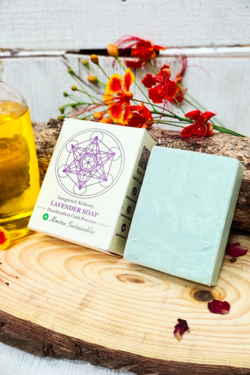 Lavender handmade cold process soap by Almitra Sustainable displayed with eco-friendly packaging on a wooden slab with natural flowers and oil bottle, calming aromatherapy soap bar made using traditional cold process method for gentle natural skincare.