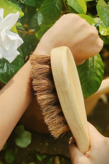 Natural dry brushing in action using Almitra Sustainables’ coconut fiber body brush – a sustainable self-care tool that promotes glowing skin and lymphatic health.
