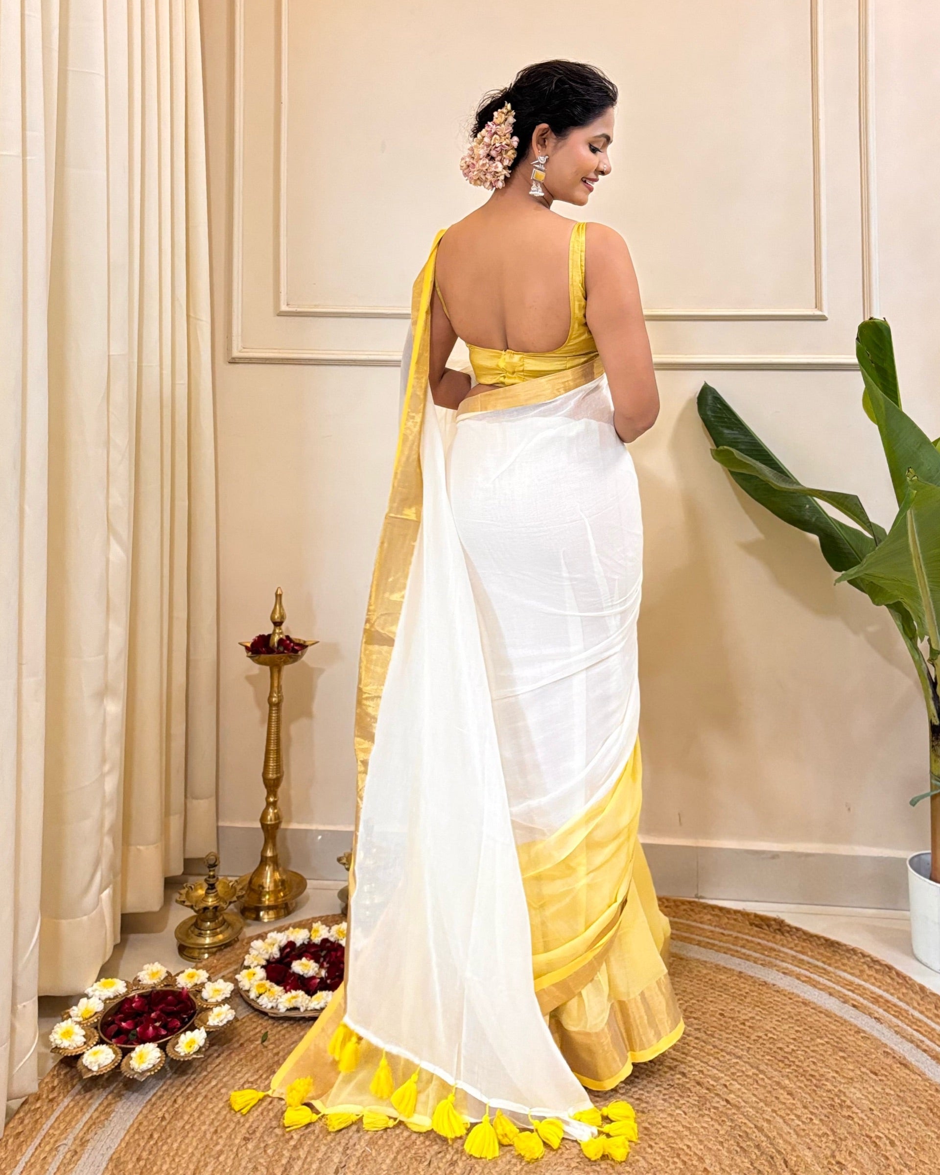 White and gold mulmul cotton saree featuring traditional Onam styling