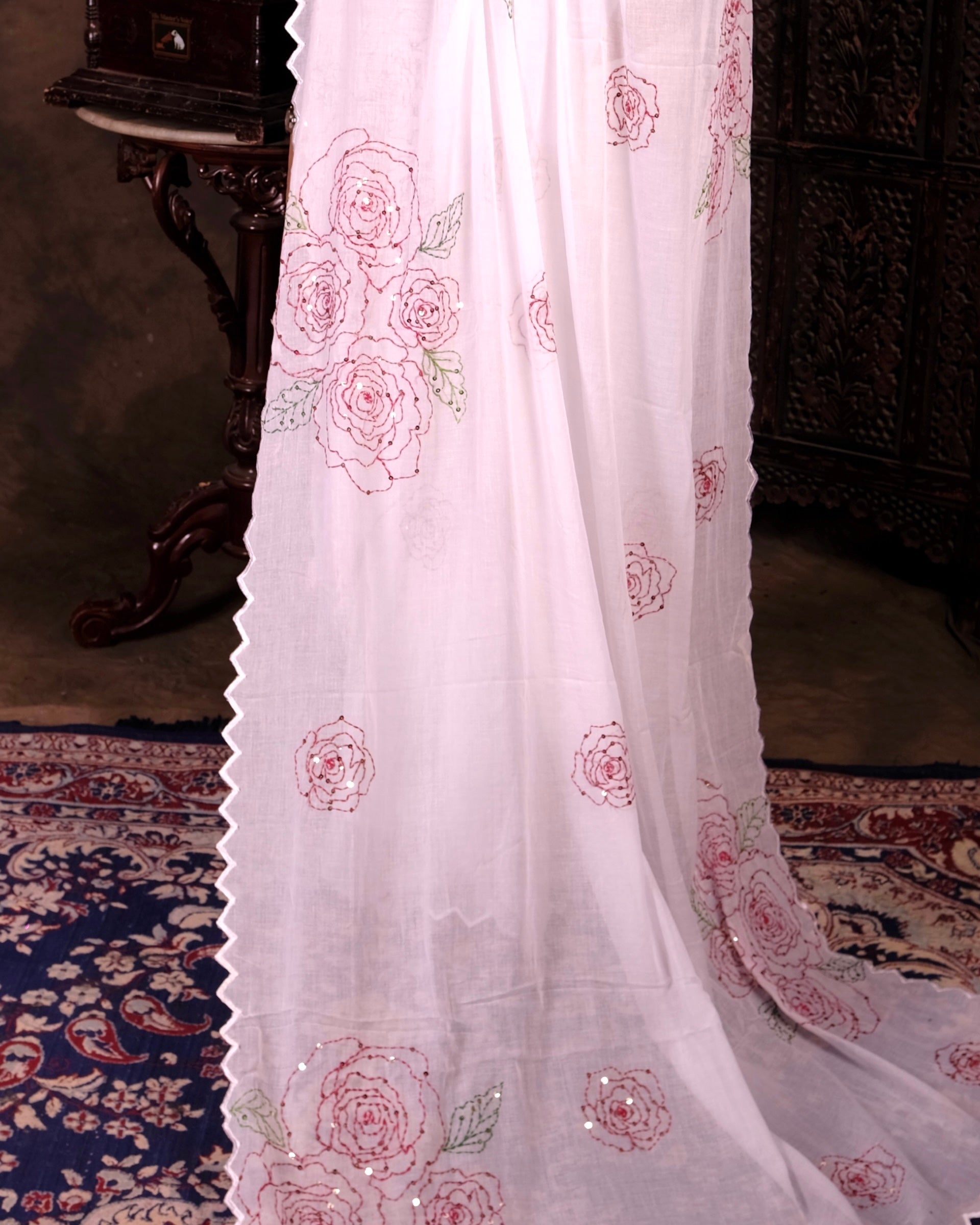 Lightweight white sequins embroidered mulmul cotton saree, designed for festive wear with a soft graceful drape.