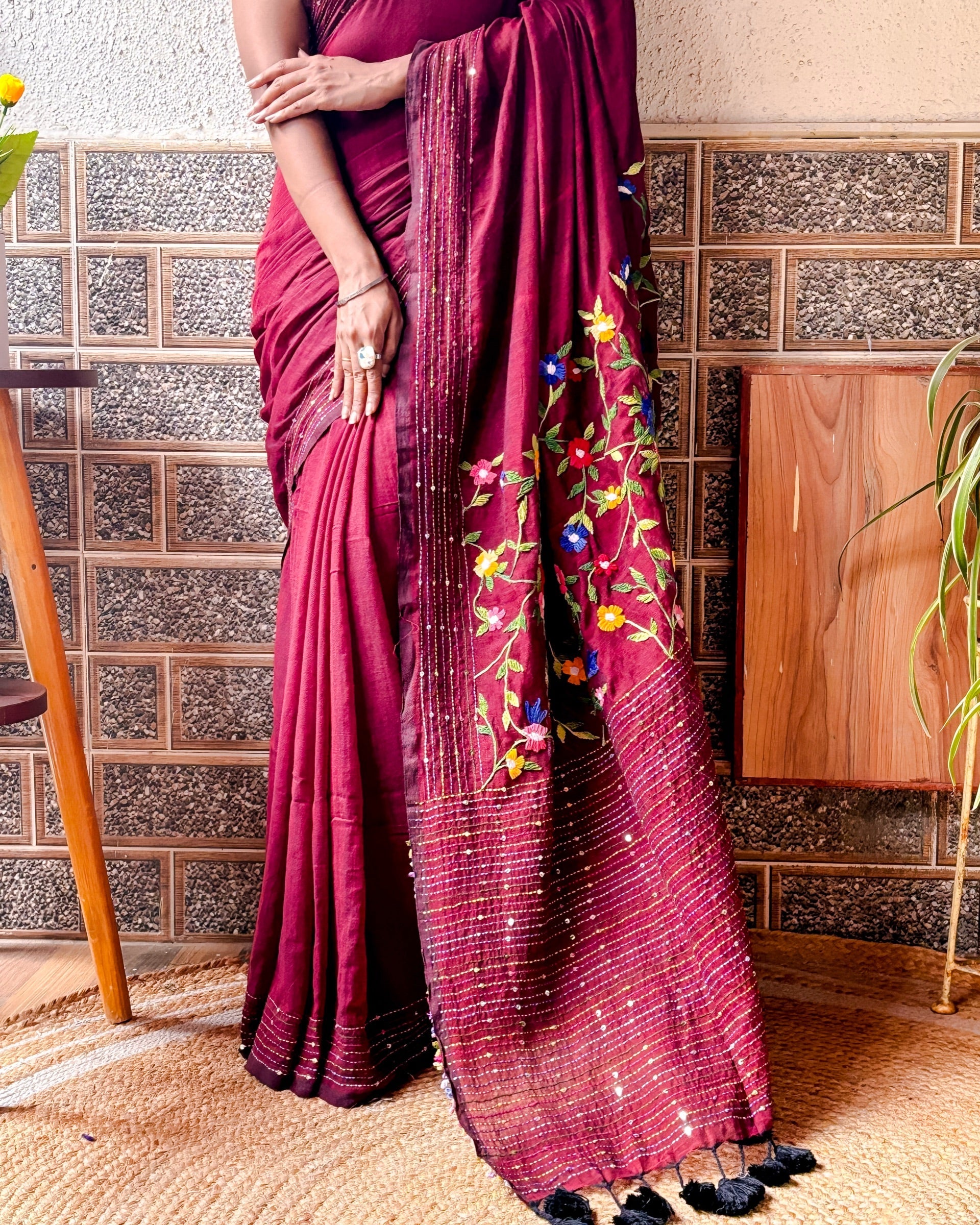 Woman wearing a soft maroon mulmul cotton saree with handcrafted thread work design