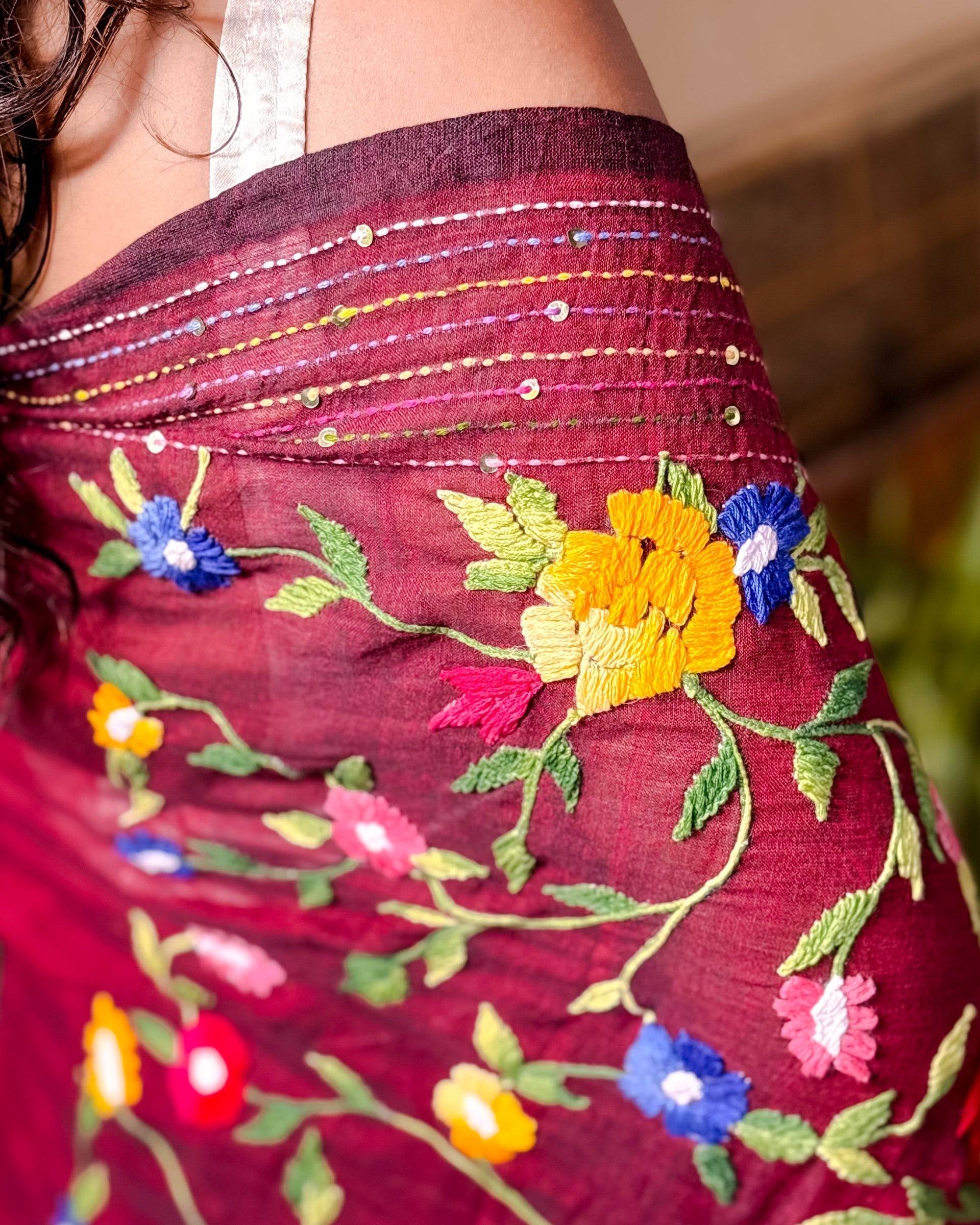Woman wearing a soft maroon mulmul cotton saree with handcrafted thread work design