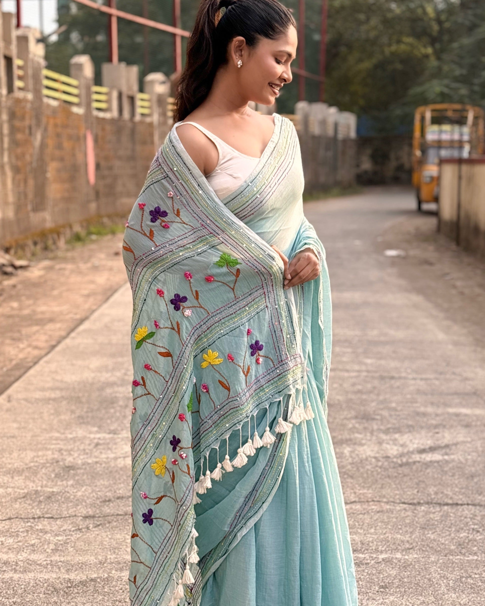 Traditional Indian cyan mulmul saree with detailed embroidery work
