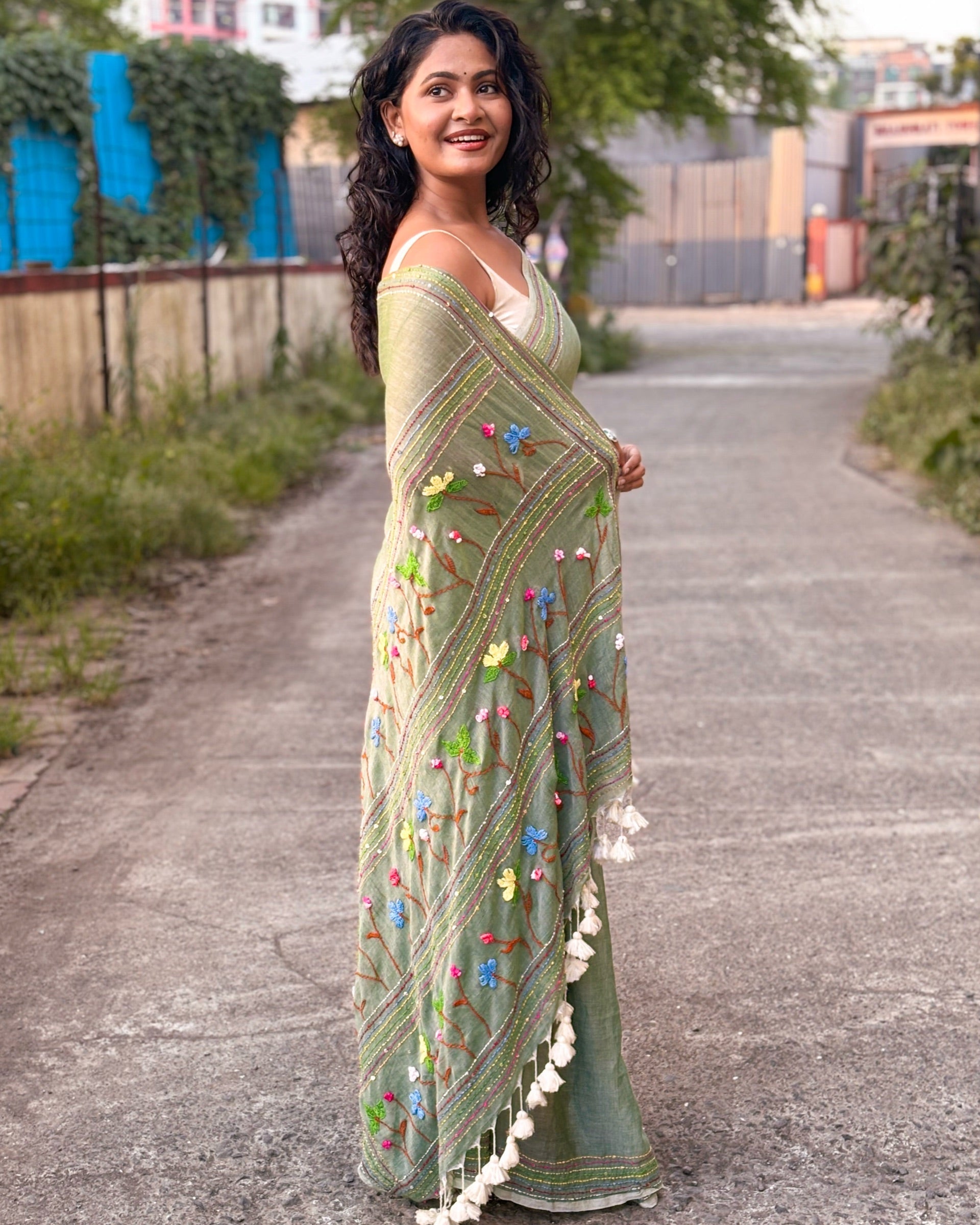 Green mulmul cotton saree featuring elegant embroidered detailing
