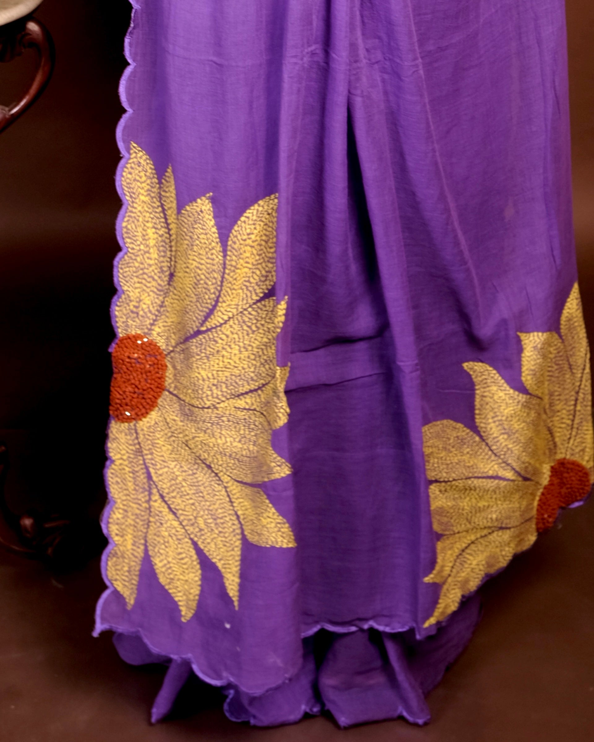 Lightweight white embroidered mulmul cotton saree with sunflower detailing, perfect for festive wear and warm days.