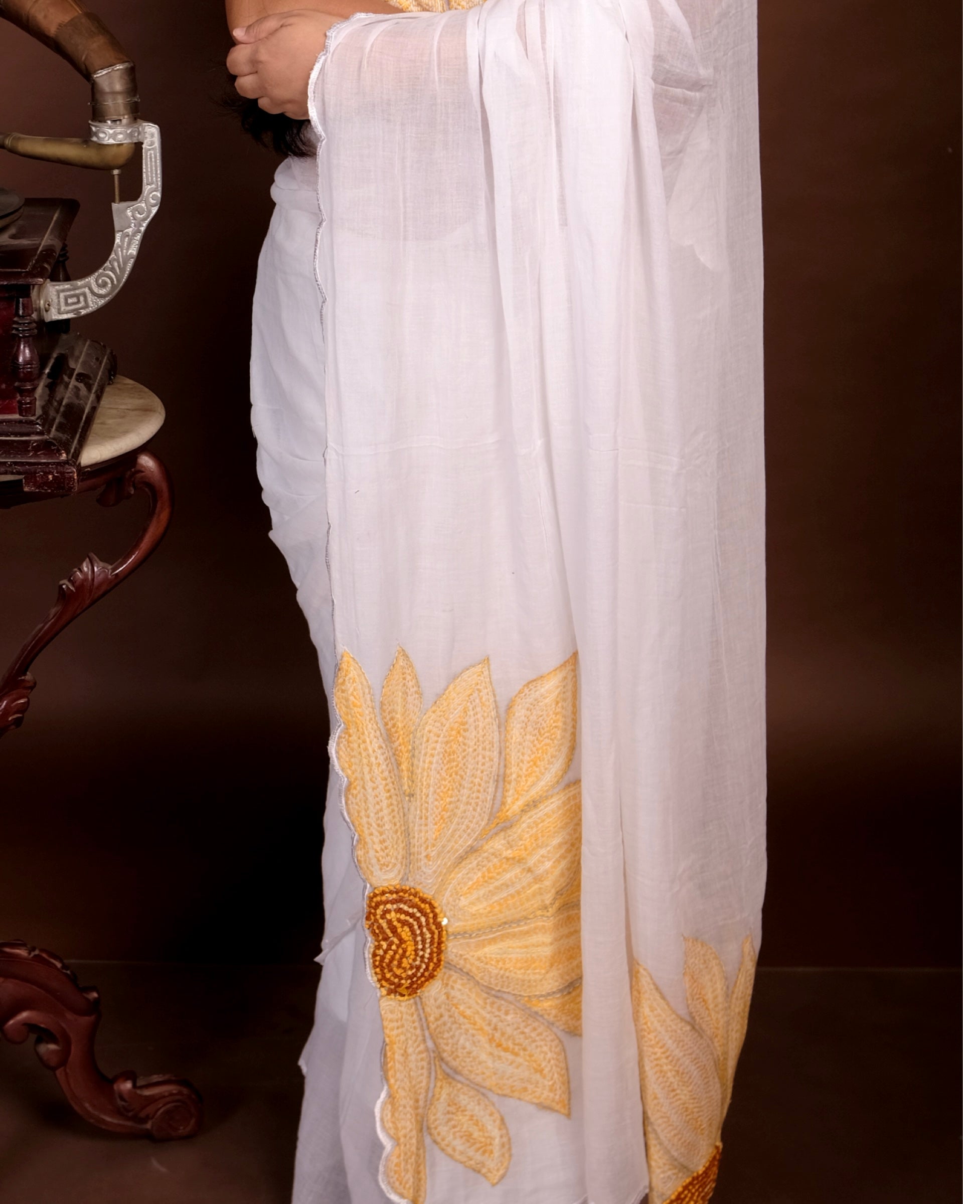 Sunshine Bloom white cotton saree, handcrafted with sunflower embroidery for a breathable and graceful summer look.