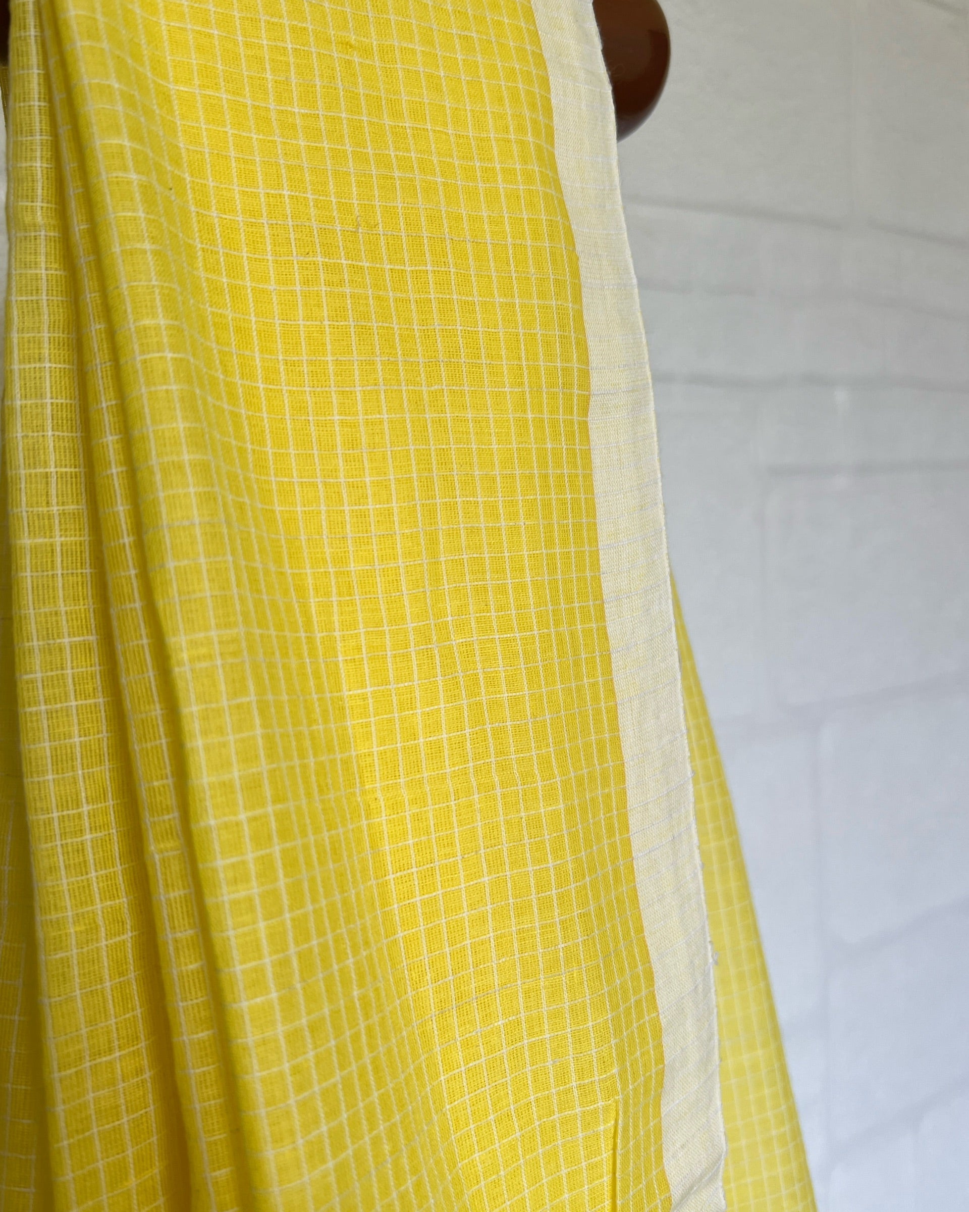 Yellow checkered handloom saree with a white background