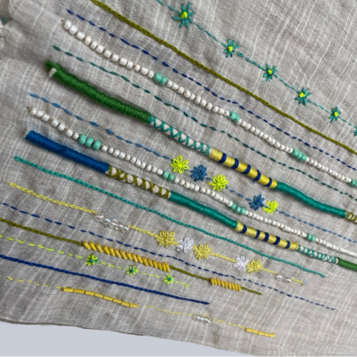 Embroidered fabric with colorful thread patterns on a gray background