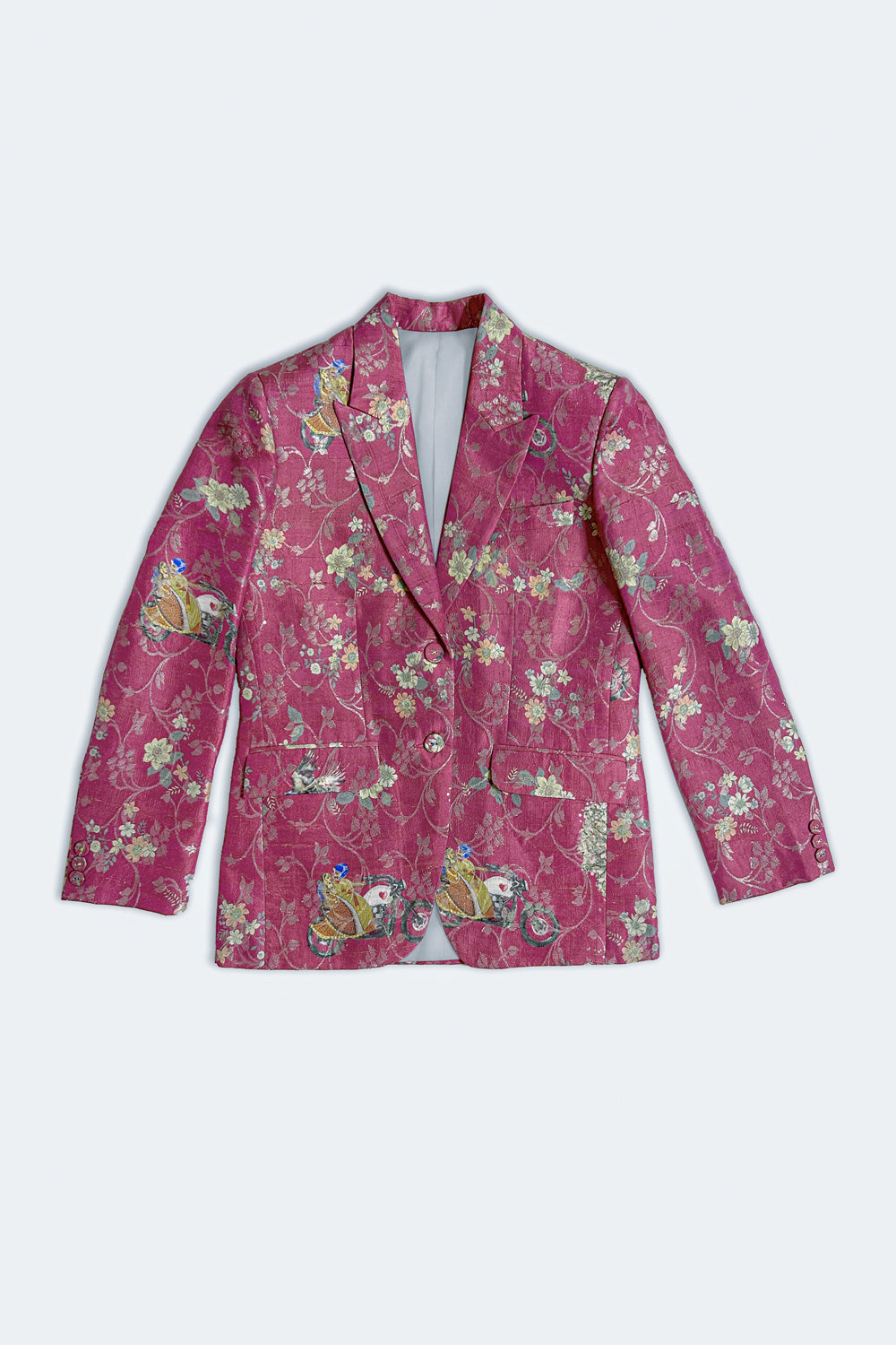 A pink silk blazer jacket featuring an intricate floral and bird pattern in green, yellow, and white, displayed flat against a light gray background.