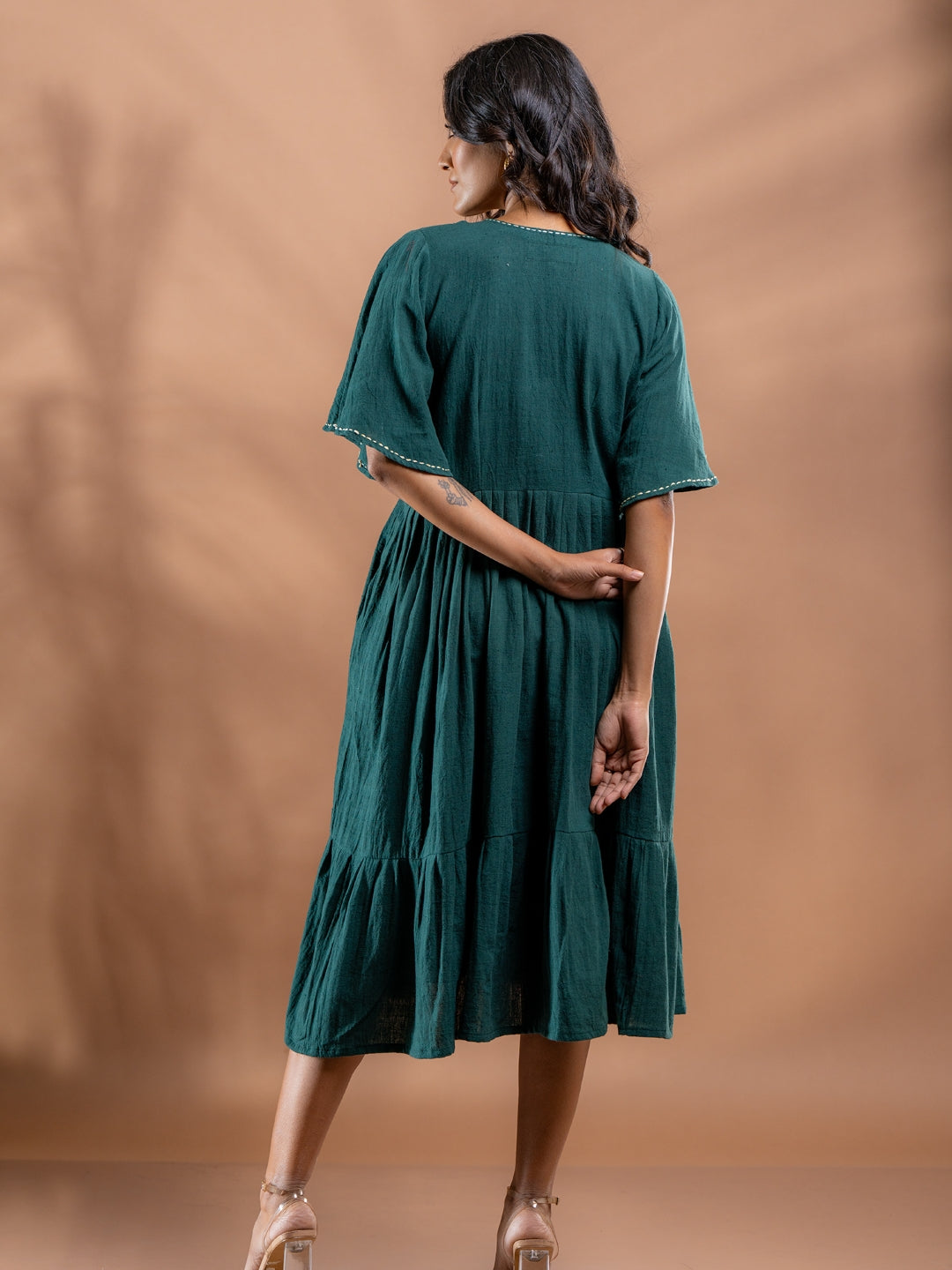 Back view of teal green kala cotton dress with gathered waist and flared hem