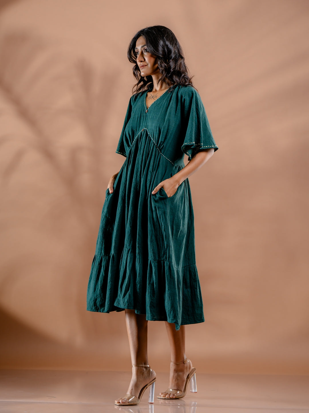 Side view of ocean fern kala cotton dress in teal green featuring pockets details and comfort fit. ethically made in India.