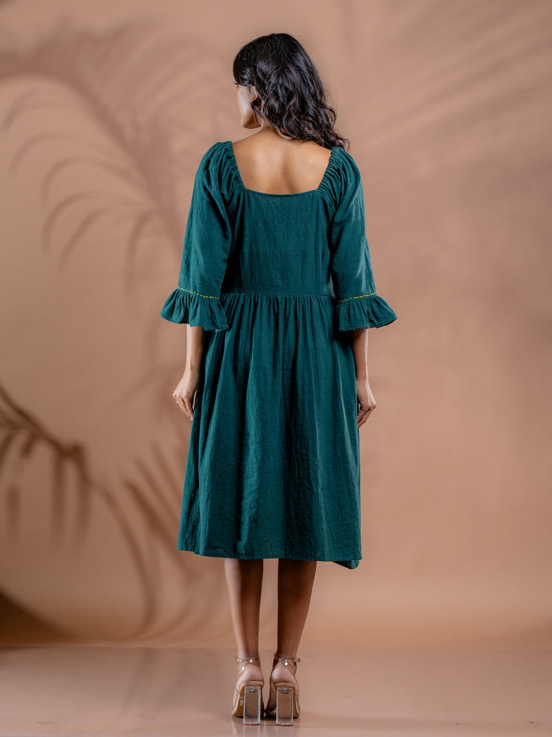 Back view of teal green women's kala cotton summer dress showing gathered flare and 3/4 sleeves