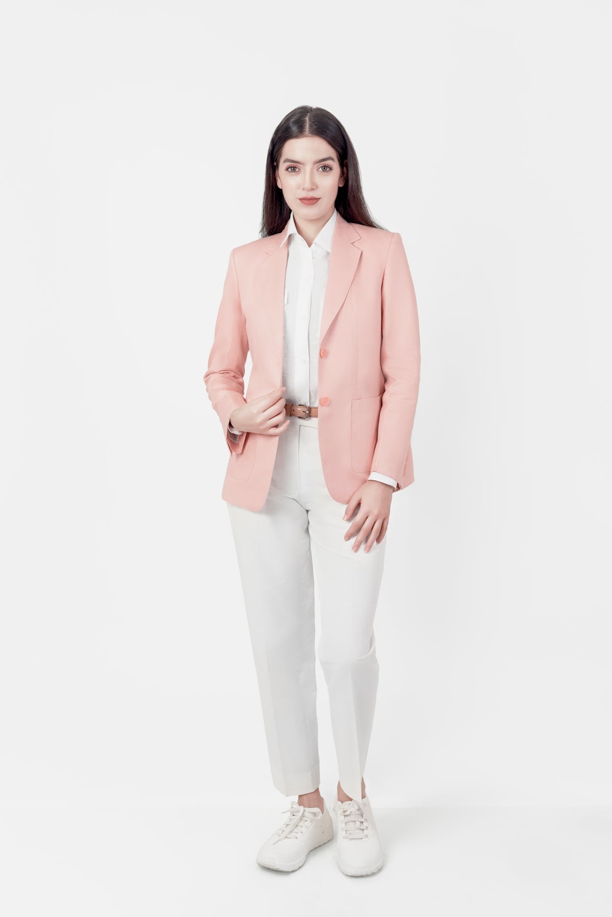 Woman wearing a pink hemp blazer, white shirt, and white pants on a white background