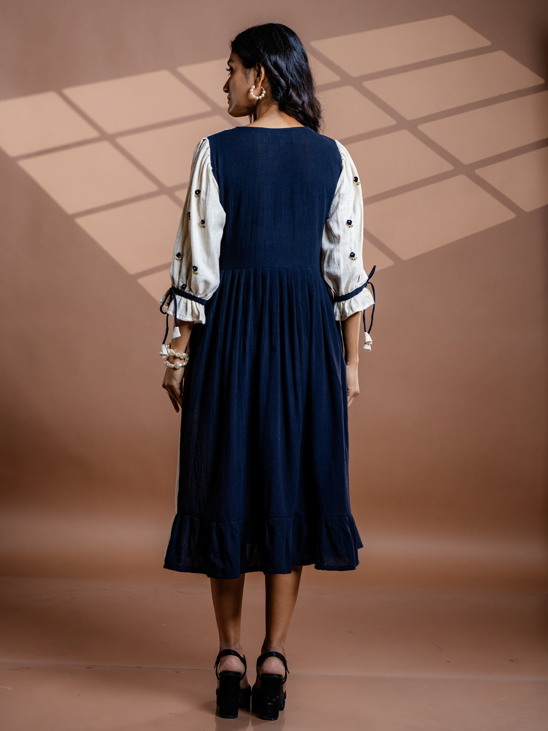 Back view of Selene black kala cotton midi dress showing flowy silhouette and gathered waist