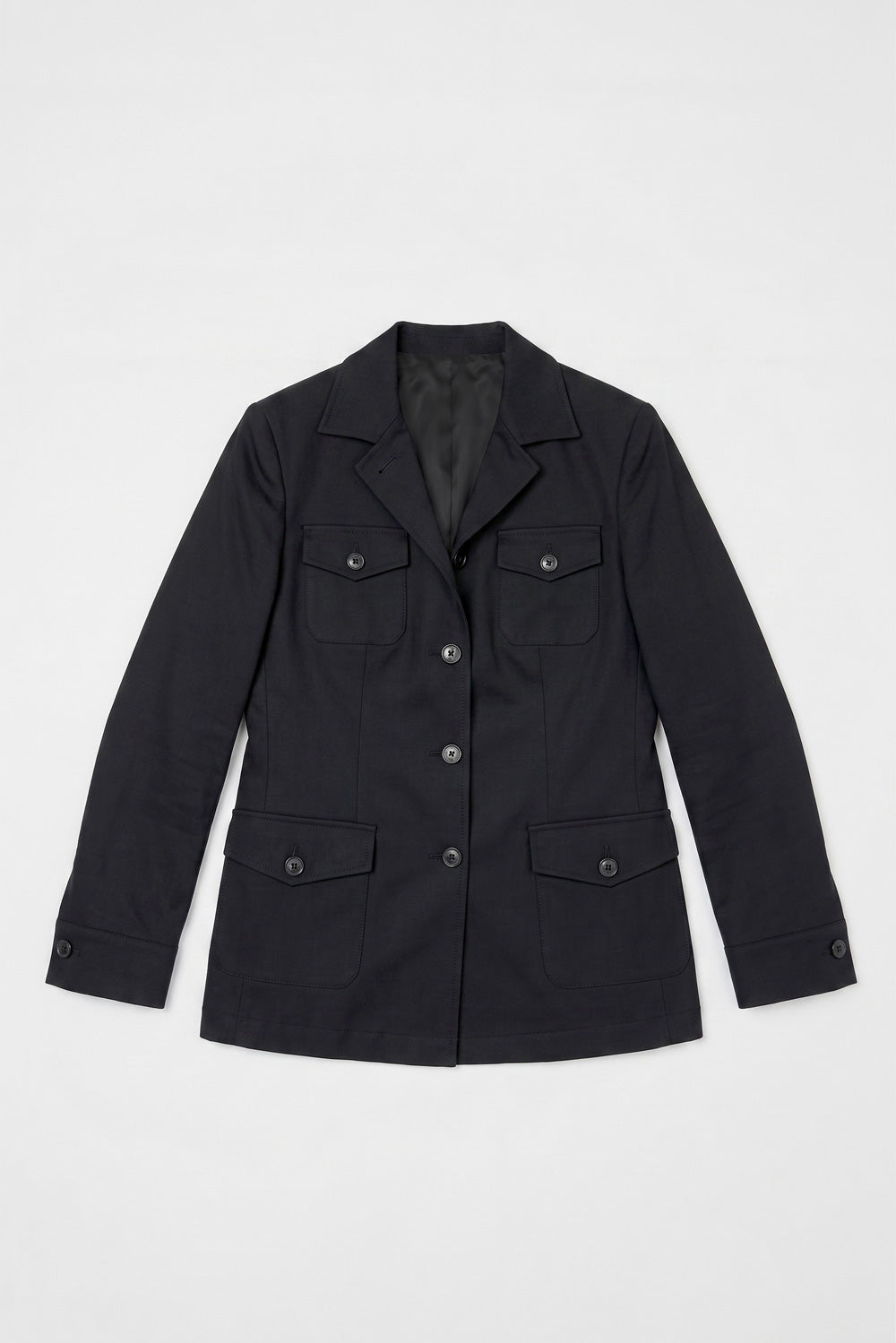 A black utility-style linen jacket with a pointed collar, front button closure, and four flap pockets, laid flat against a light gray background.