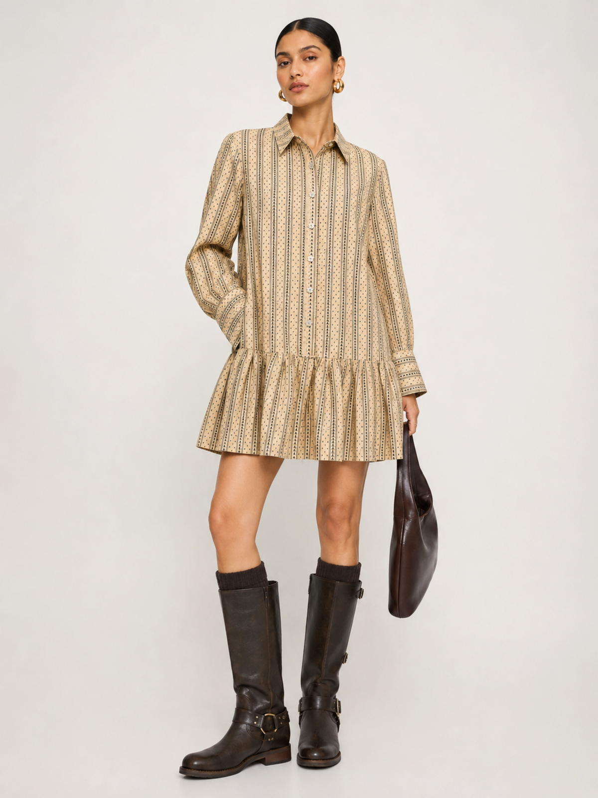 Woman wearing a patterned dress and black boots on a white background