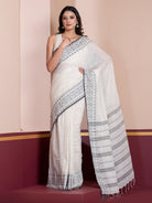 A woman modeling a white khadi cotton saree with a striped pattern and Jamdani border.