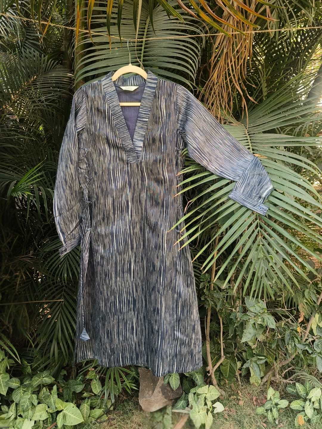 Siona Kurta- Handwoven Tussar Silk | Jhultaru. Fabric: 100% Handwoven Tussar Silk  Color: Indigo with white striations  Features:Deep V-neck with contrast inner panelFull-length sleeves with cuffSide tie-up for adjustable fit- Siona Kurta in handwoven tussar silk with indigo striations, featuring a deep V-neck and tie-up detail. A versatile silhouette in rich, breathable silk that is eco-friendly and sustainable.
