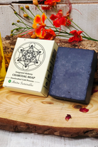 Chocolate coffee handmade cold process soap with Almitra Sustainable packaging placed on rustic wooden surface with flowers and natural ingredients, eco-friendly artisan soap bar designed for deep cleansing, exfoliation and natural skincare.