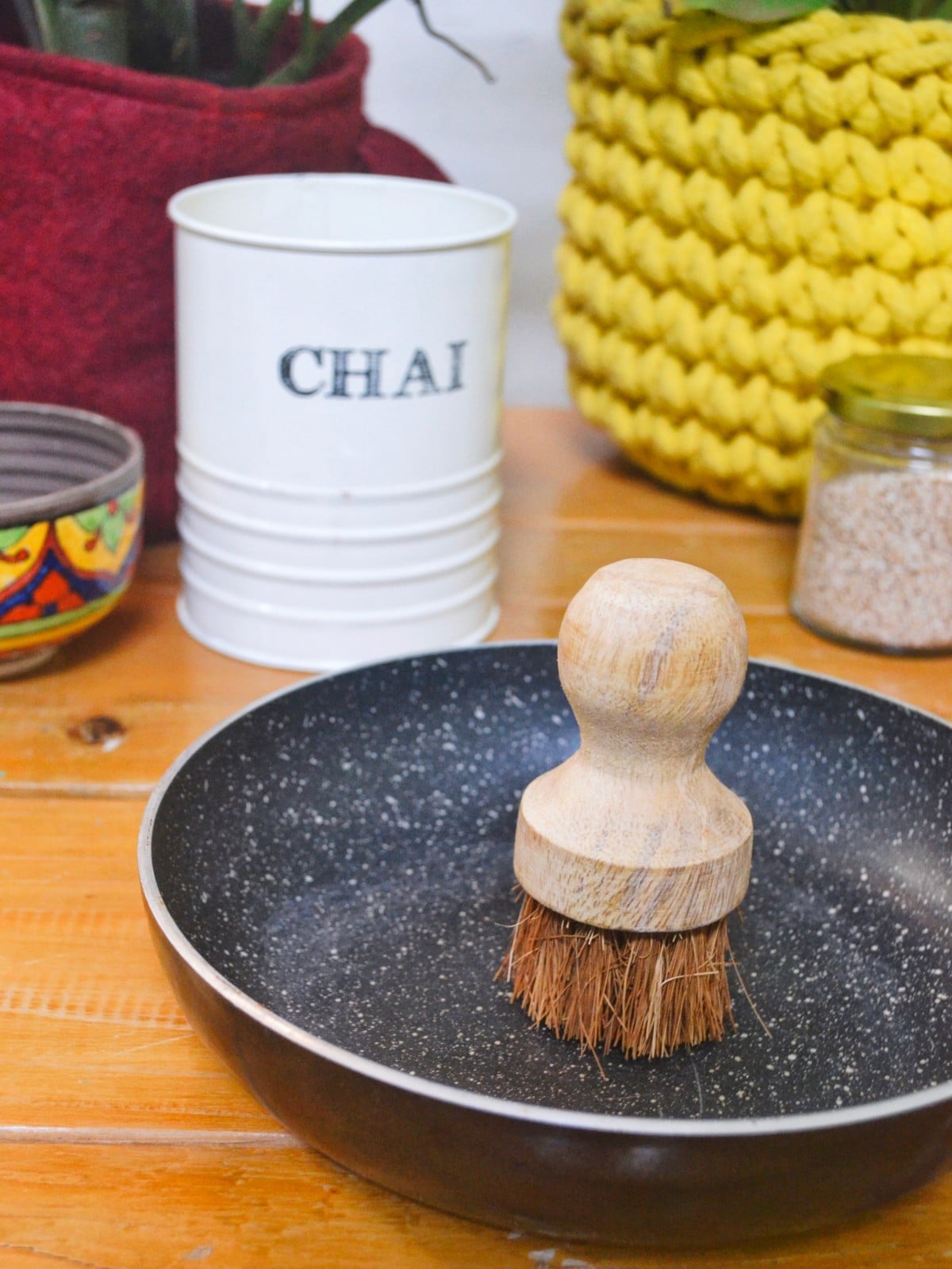 Almitra Sustainable wooden dish scrubber with natural coconut fibre bristles placed inside a pan, eco-friendly plastic-free kitchen cleaning brush.
