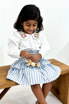Capri Blouse and Amalfi Skort set flat lay showing both pieces in GOTS-certified organic cotton