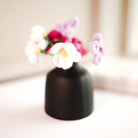 black bud vase with mini crochet daisies - https://artecasa.in/
