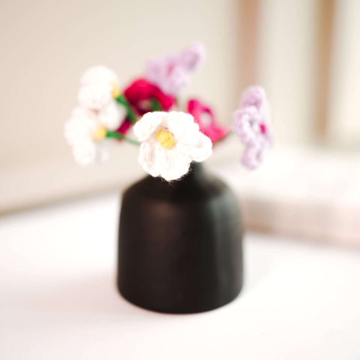 black bud vase with mini crochet daisies - https://artecasa.in/