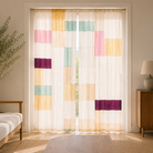 Living room with a white sofa, wooden coffee table, and colorful geometric-patterned curtains.