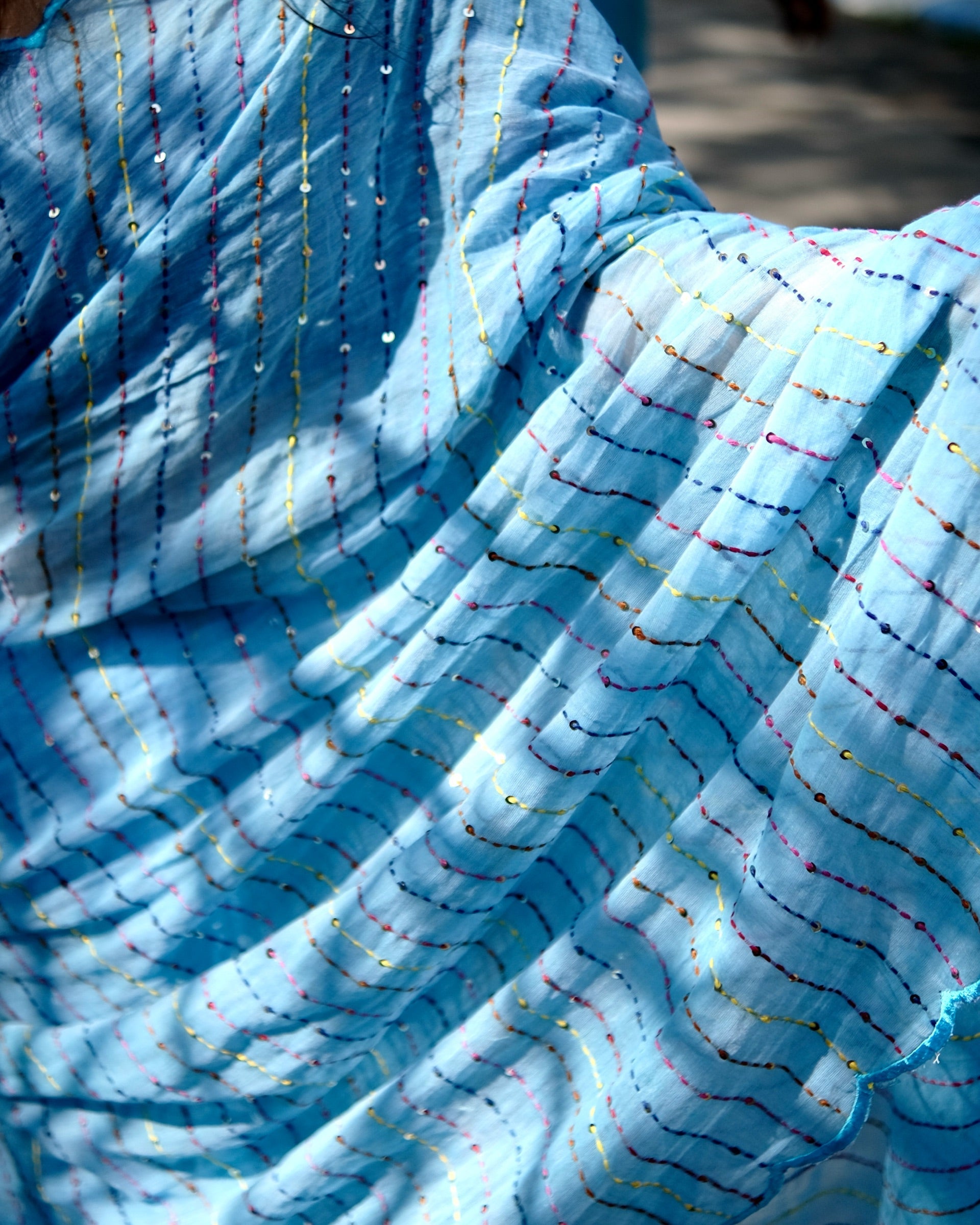 Lightweight blue embroidered mulmul cotton saree with sequins detailing, perfect for festive wear and summer comfort.