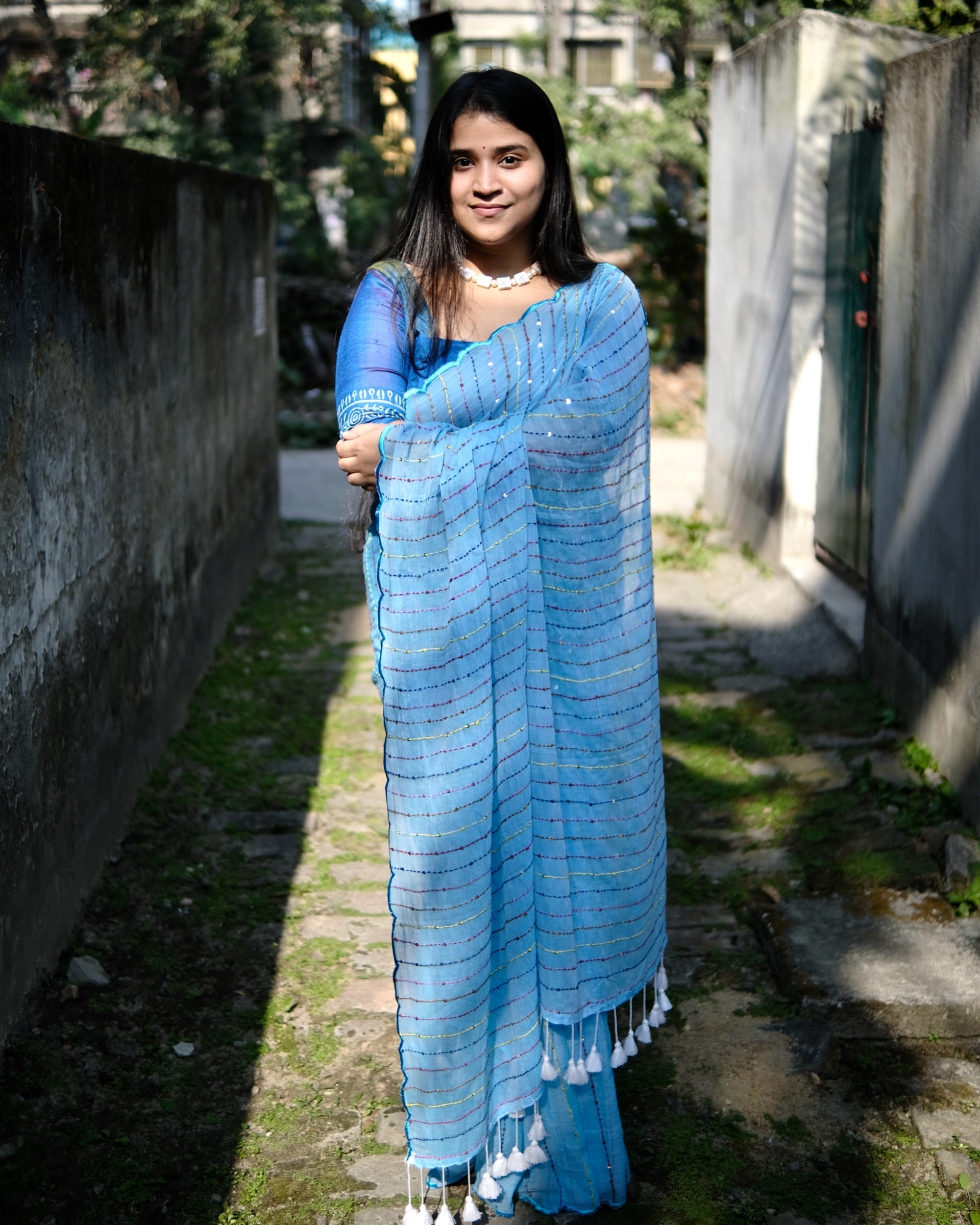 Blue mulmul cotton saree with multicolour embroidery and sequins, soft airy elegance for summer styling and festive moments.