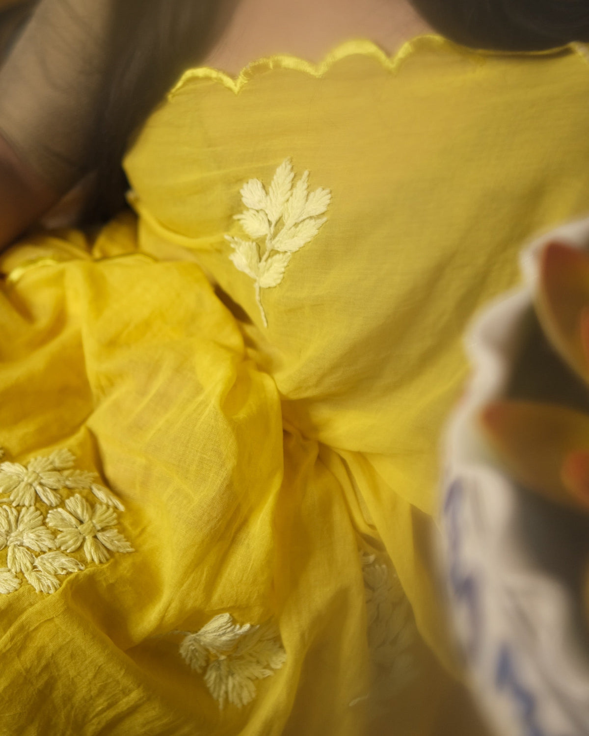 Yellow mulmul cotton saree with traditional chikankari embroidery, a breathable saree for summer and festive occasions.