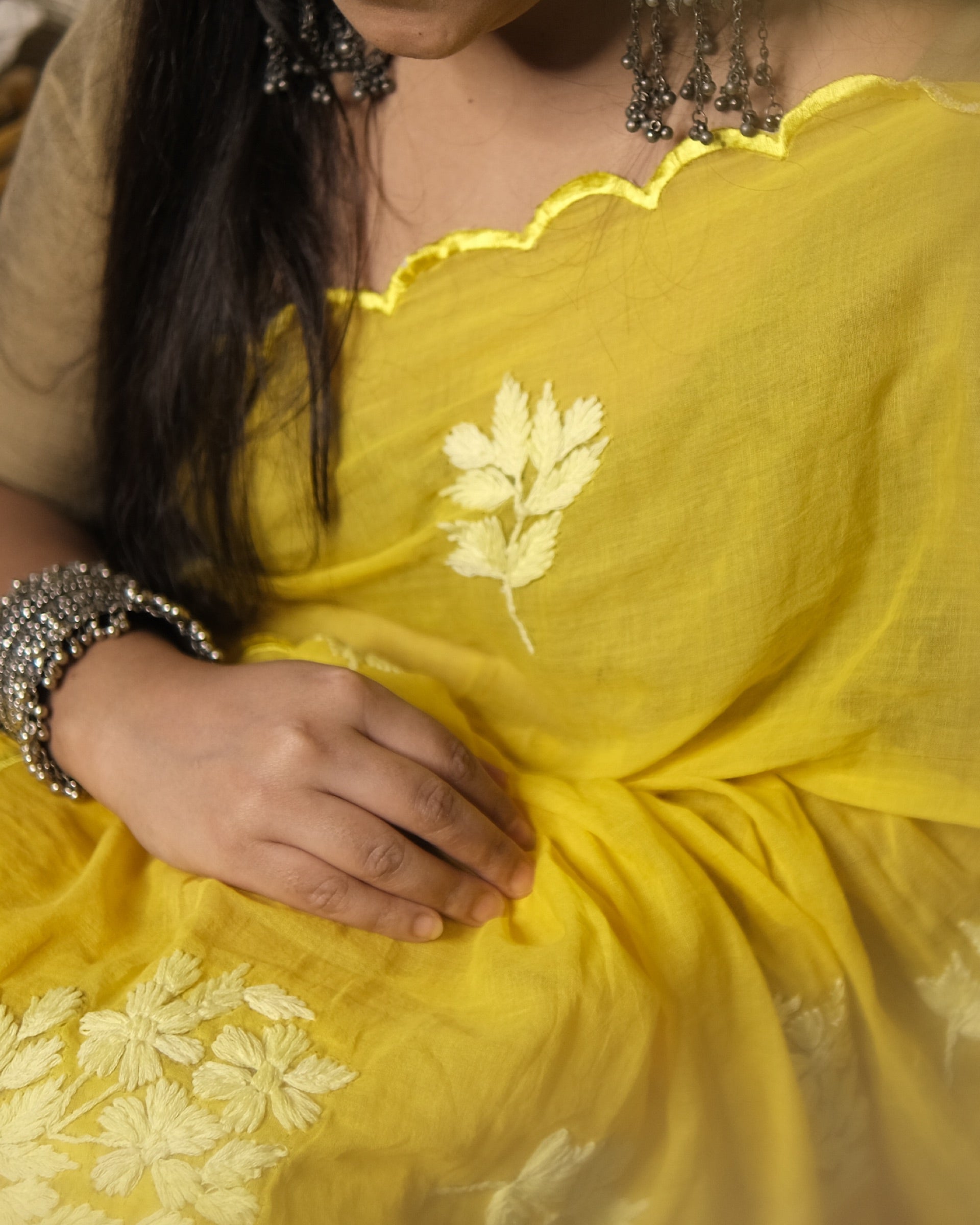 Lightweight yellow chikankari embroidered mulmul cotton saree, designed for festive wear with soft comfort.