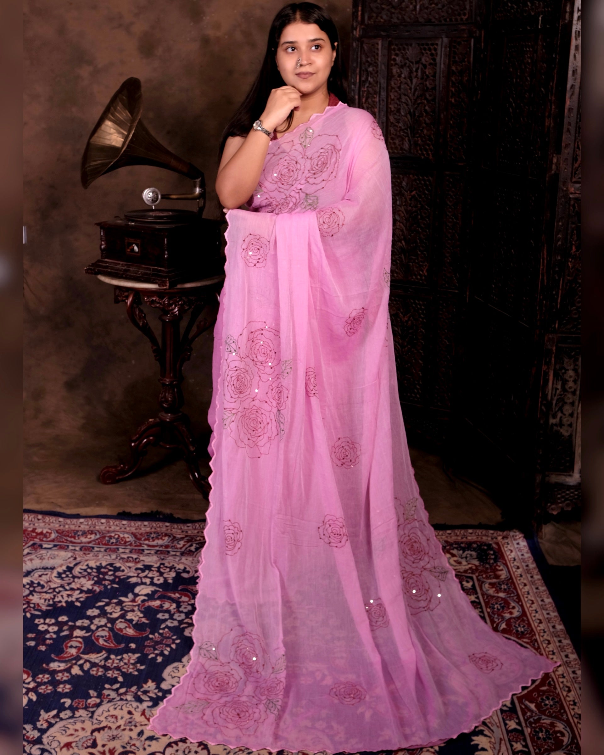 Pink mulmul cotton saree with rose detailing and sequins embellishment, lightweight elegance for festive occasions and celebrations.