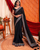 Woman in a black mulmul cotton saree with sequins embellished border - festive saree