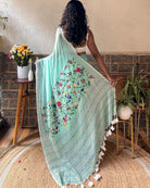 Woman wearing a soft green mulmul cotton saree for everyday comfort