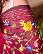 Woman wearing a soft maroon mulmul cotton saree with handcrafted thread work design