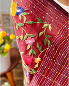 Handcrafted maroon mulmul cotton saree featuring soft breathable fabric and elegant thread work