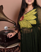 Green mulmul cotton saree with delicate embroidery, soft airy elegance for summer days and festive moments.