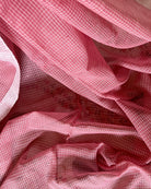 Close-up of pink checkered handloom cotton saree with a soft focus