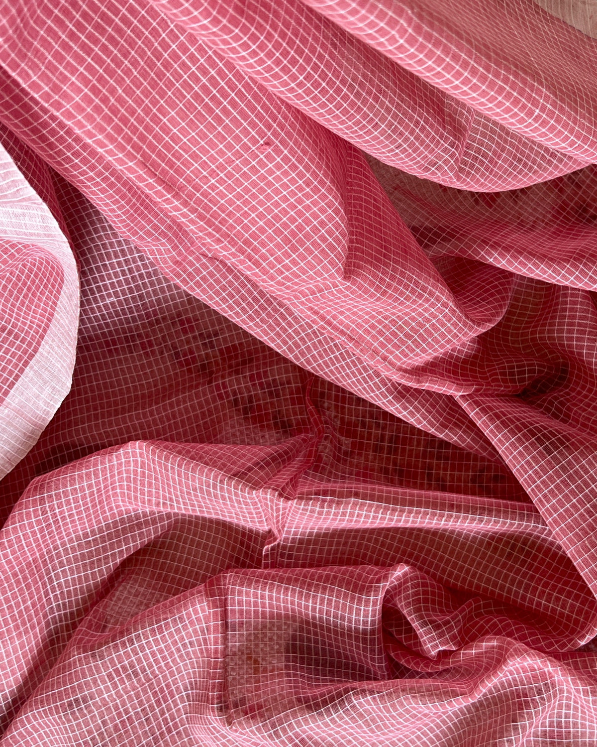 Close-up of pink checkered handloom cotton saree with a soft focus