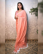 Soft and Comfortable mulmul cotton saree in peach pink shade with sequin emblishment for festive or party wear at reasonable price