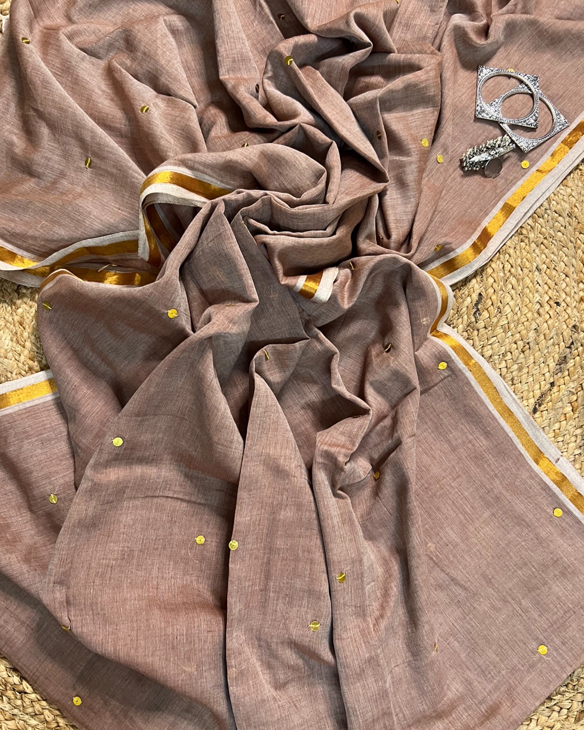 Soft and Comfortable mulmul cotton saree in beige off white brown shade with golden sequin emblishment for festive or party wear at reasonable price