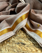 Soft and Comfortable mulmul cotton saree in beige off white brown shade with golden sequin emblishment for festive or party wear at reasonable price