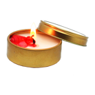 Small candle in a gold tin with a lid, featuring a red wick on a white background.