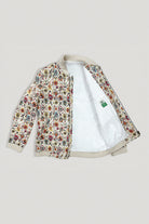 A bomber linen jacket with a dense multicolor floral print on a cream base, featuring a white sherpa lining and ribbed beige trim, shown open against a light gray background.