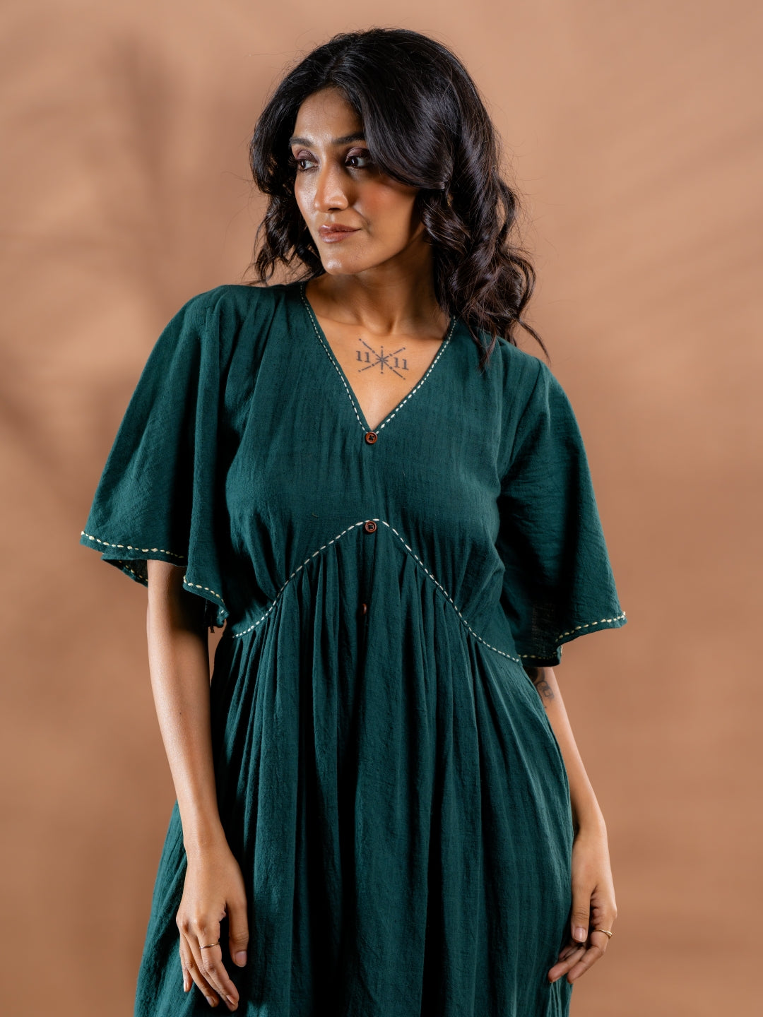 Close-up of hand embroidery and neck details of teal green kala cotton tiered dress
